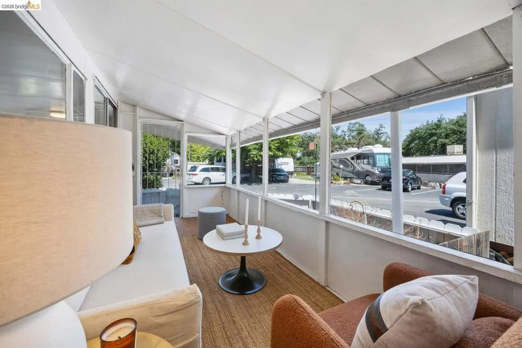 Screened porch featuring a sloped white ceiling, wood-finish flooring, and multiple window panels