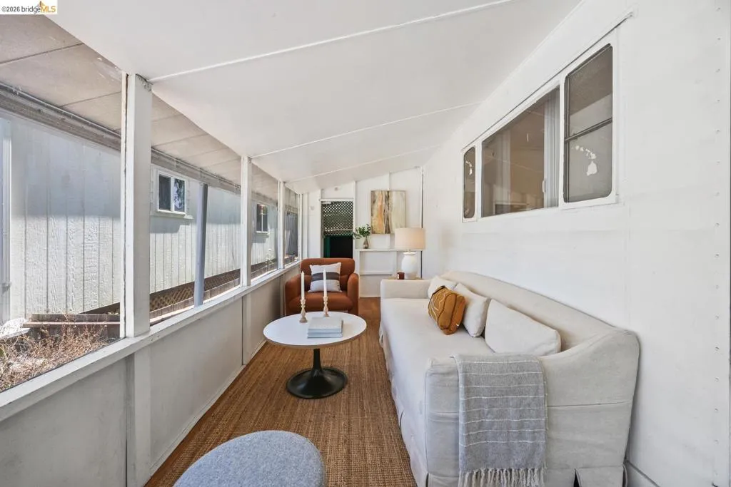 Screened-in porch featuring white walls, sloped ceiling, wood-finish flooring, and multiple window panels