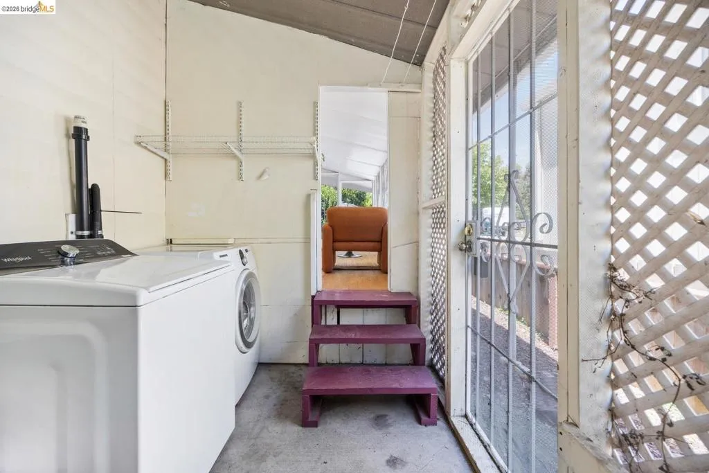 Utility area with concrete flooring and white panel walls
