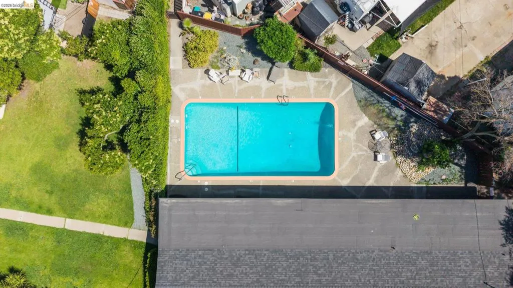 Rectangular swimming pool with a light blue interior, surrounded by a flagstone patio