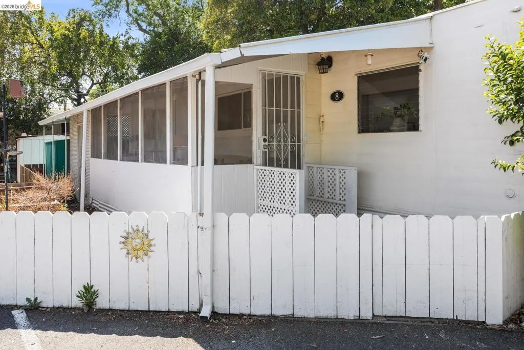 White picket fence entry with a sunburst accent