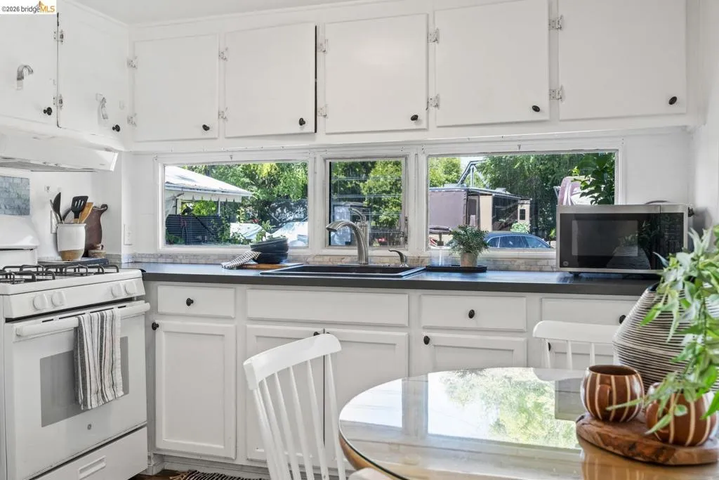 Bright kitchen featuring white cabinetry and dark countertops