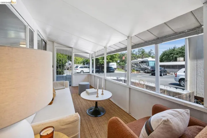 Screened porch featuring a sloped white ceiling, wood-finish flooring, and multiple window panels
