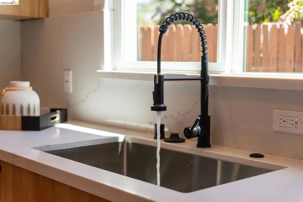Stainless steel undermount sink with a matte black high-arc pull-down faucet