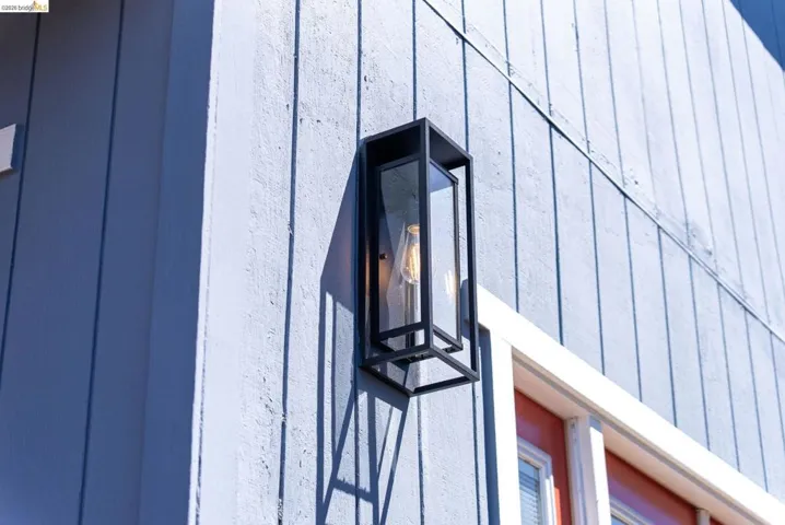 Vertical plank siding with an exterior wall lantern featuring a black metal frame and clear glass panels
