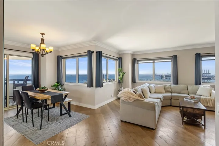 Spacious living and dining area with large view windows, a comfortable open layout, and beautiful ocean and harbor outlooks
