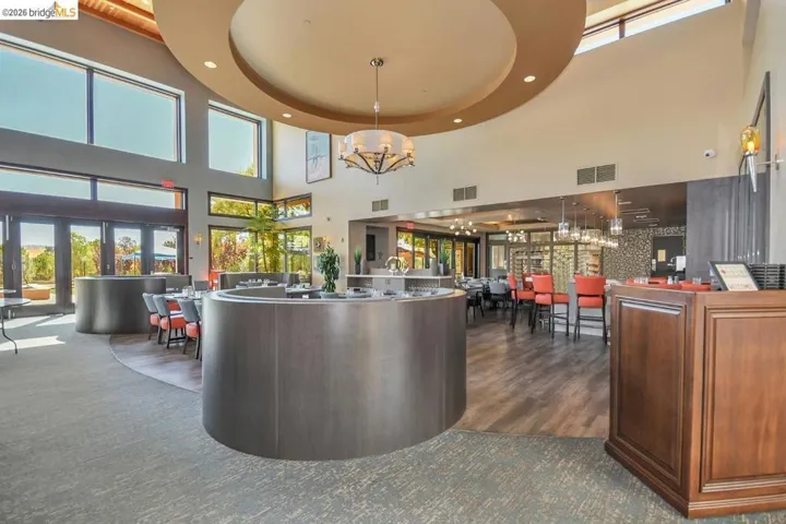 Spacious interior featuring a high vaulted ceiling with a circular tray element and chandelier