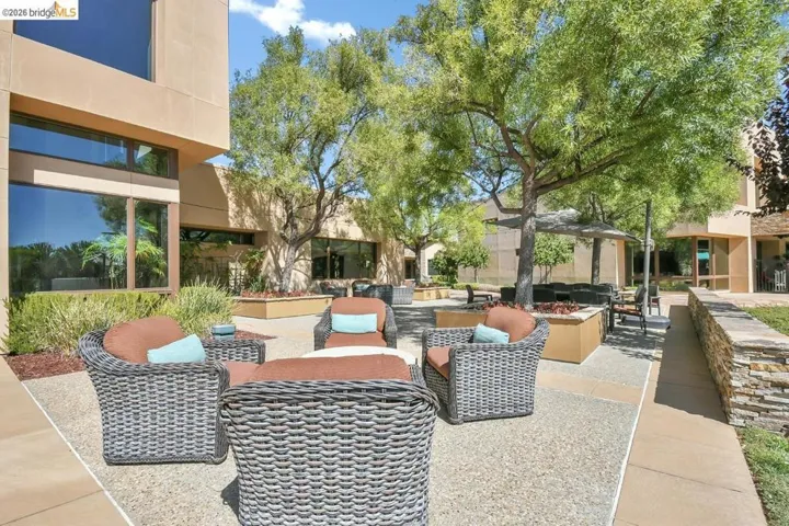 Outdoor patio space featuring a stone veneer retaining wall and ample natural light