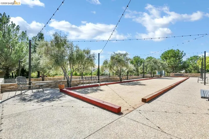 Outdoor bocce ball court featuring a gravel playing surface and perimeter wood curbing