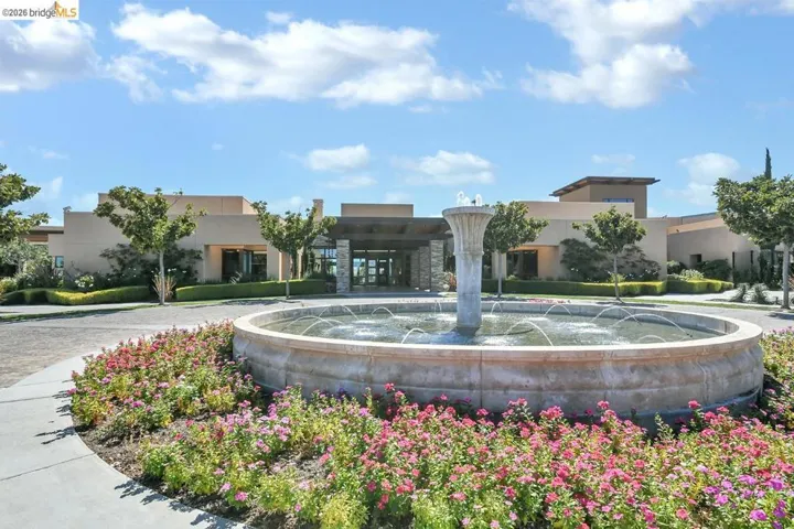 Circular stone fountain feature surrounded by colorful landscaping