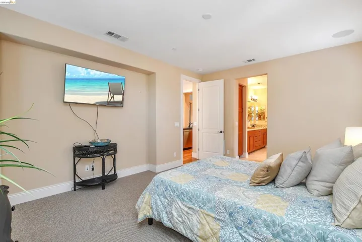 Carpeted sleeping area featuring a recessed wall niche and crown molding