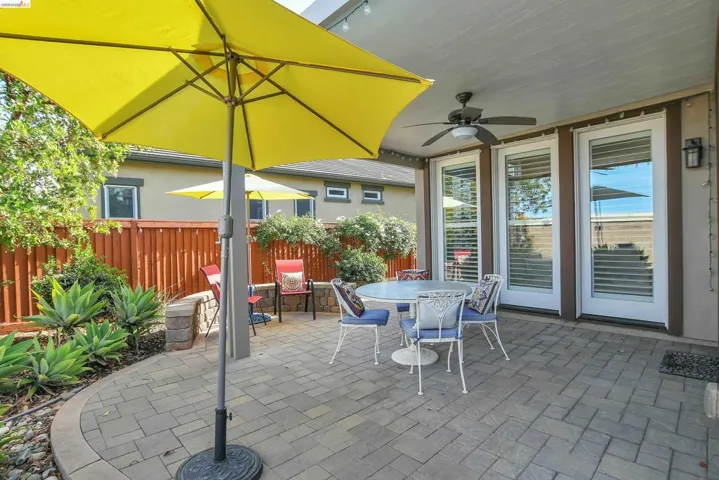 Outdoor patio featuring paver flooring, a covered ceiling with a ceiling fan, and multiple French doors