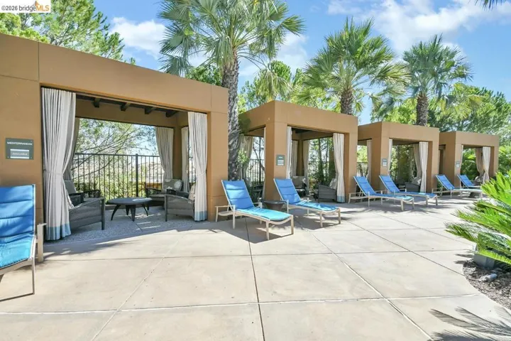 Outdoor cabanas featuring light-colored privacy curtains and an open-air lounge area