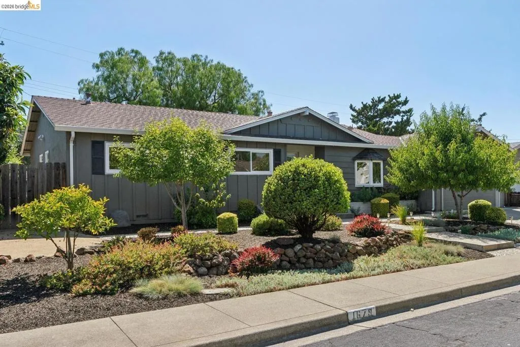 Ranch-style residence featuring a gray exterior, shuttered windows, and a bay window