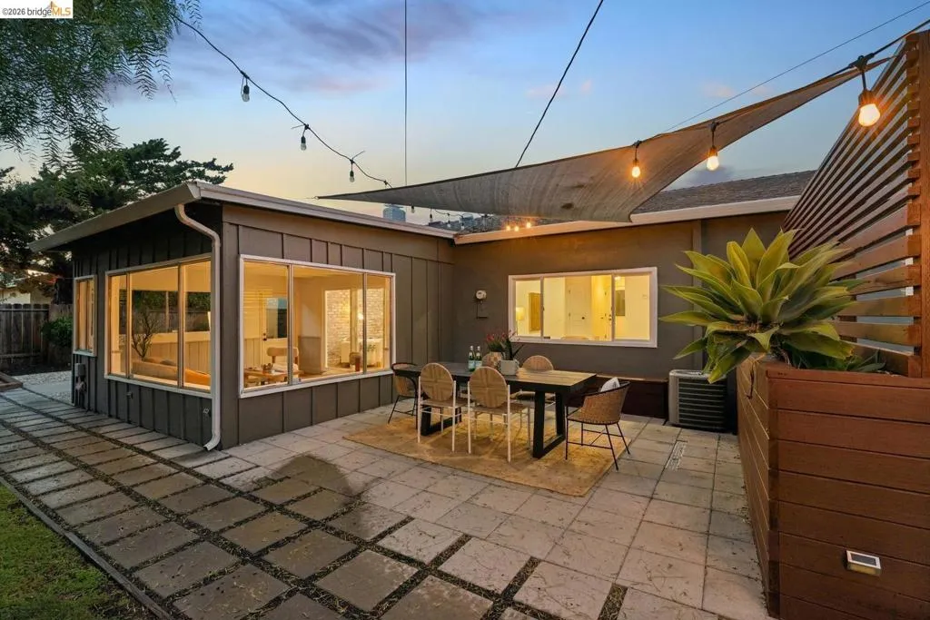Private patio featuring square paver stones, a shade sail, and an integrated wood privacy screen