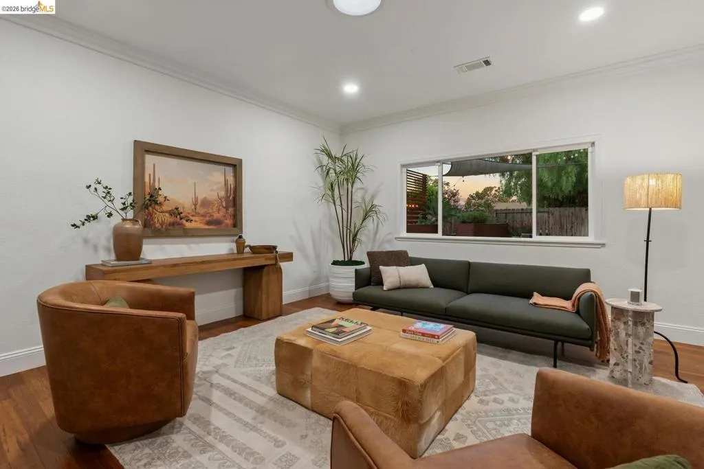 Spacious living area featuring wood-finish flooring, white walls, and recessed lighting