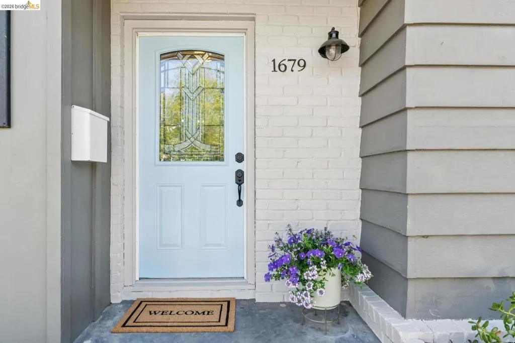 Light blue entry door with decorative glass inserts and black hardware
