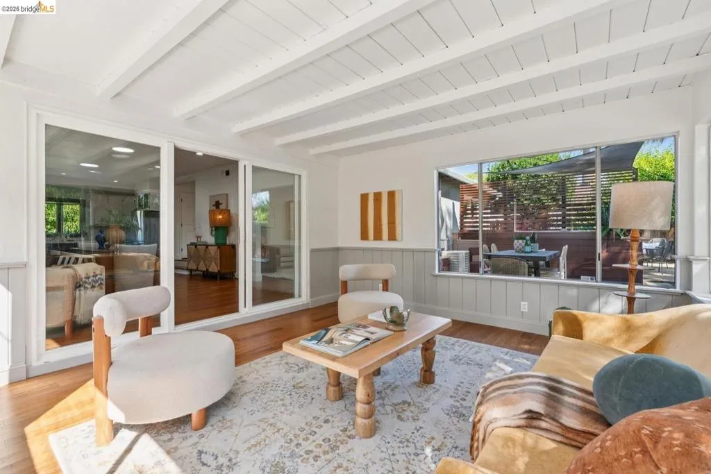 Hardwood flooring and a paneled ceiling with exposed beams