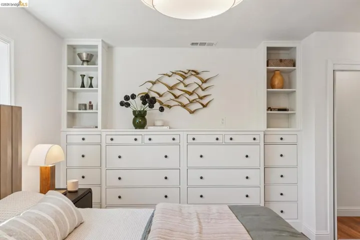 Custom built-in cabinetry featuring white finishes and black hardware, integrated storage with open shelving, and recessed lighting