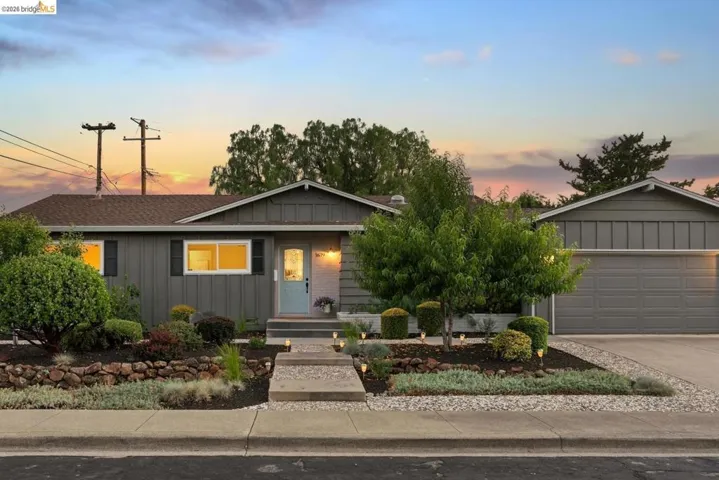 Ranch-style exterior featuring gray siding, a light blue entry door, and a two-car garage