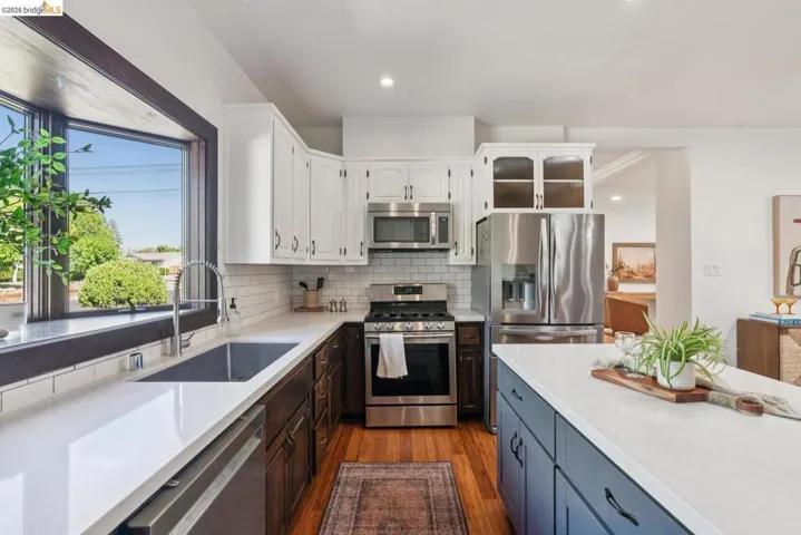 Modern kitchen featuring a two-tone cabinetry design with white upper cabinets and dark wood-finish lower cabinets