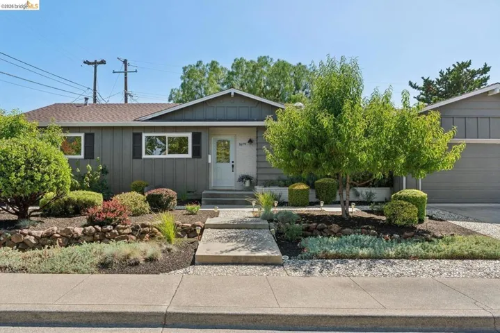 Ranch-style exterior with gray vertical siding and white trim