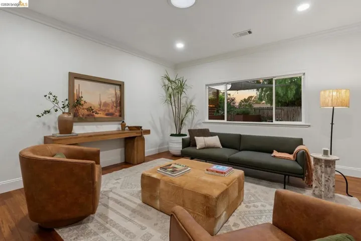 Spacious living area featuring wood-finish flooring, white walls, and recessed lighting