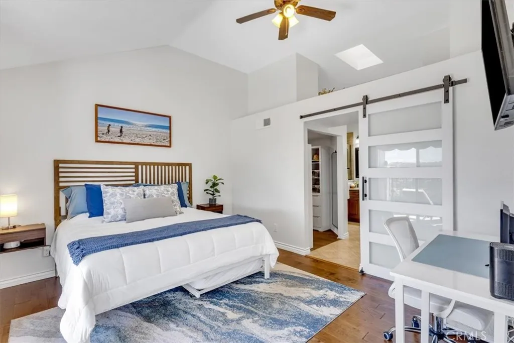 The spacious primary suite is located on the main floor and includes ceiling fan and barn door to primary bath and walk-in closet.