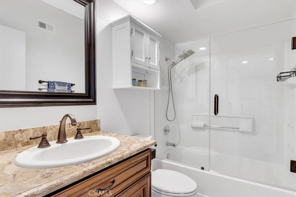 Adjacent to the second bedroom is the guest bathroom with beautiful granite topped vanity and glass enclosed shower/tub combination.