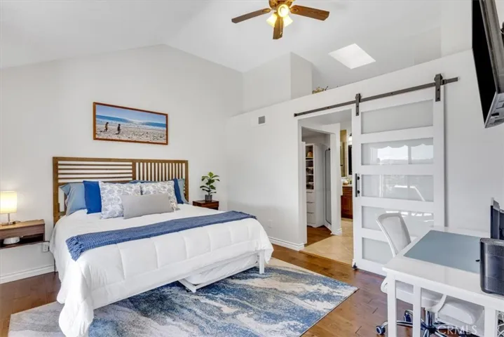 The spacious primary suite is located on the main floor and includes ceiling fan and barn door to primary bath and walk-in closet.