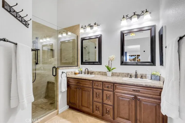 Primary bathroom has been beautifully upgraded and includes dual sinks and a step-in shower with custom tile.