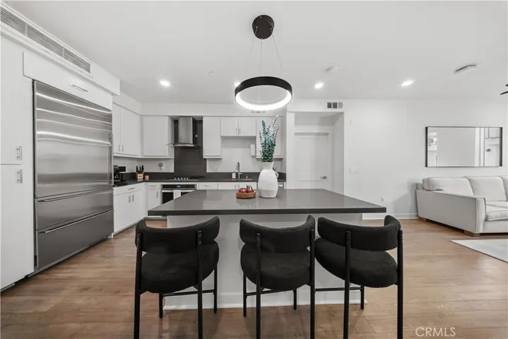 Upon entry, you are greeted by this light & bright updated kitchen, with sub zero fridge!