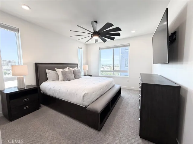 Bright and sunny primary bedroom with ceiling fan and light with remote.