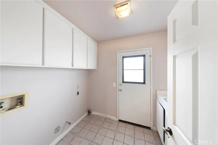 Individual laundry room with additional storage and utility sink.