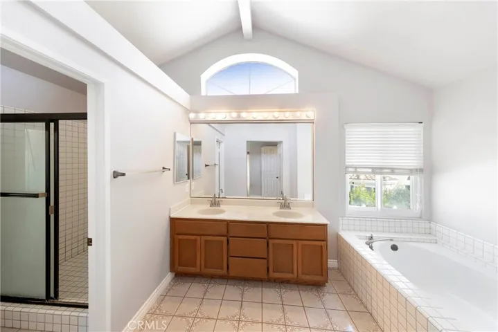 Primary ensuite featuring His and Hers vanity, walk in shower, and separate tub.
