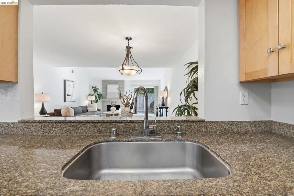 Kitchen featuring a stainless steel sink, contemporary faucet, and speckled stone countertops