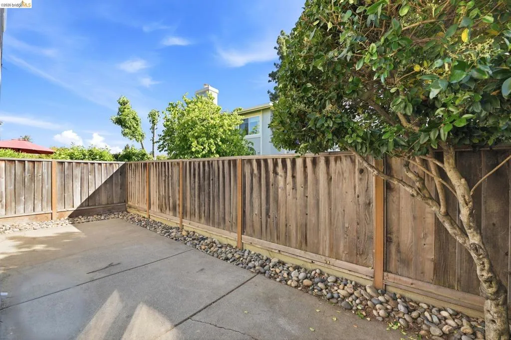 Outdoor patio area featuring a concrete slab and wood privacy fencing