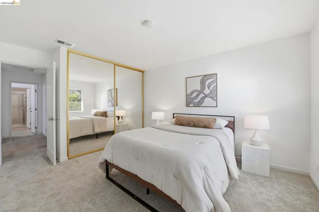 Bedroom featuring light gray carpeting, crisp white walls, and a recessed ceiling