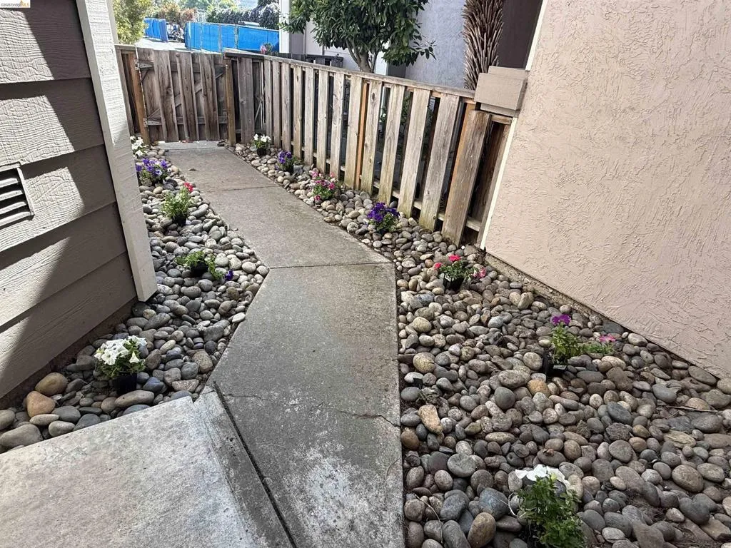 Concrete walkway bordered by river rock landscaping