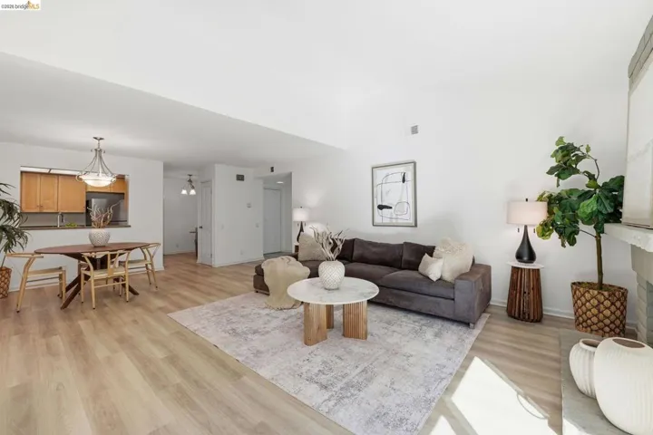 Open-concept living space featuring wood-finish flooring, a neutral color palette, and high ceilings