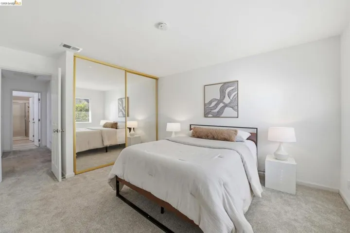 Bedroom featuring light gray carpeting, crisp white walls, and a recessed ceiling