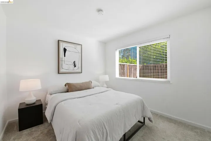 Windowed room featuring light gray carpeting, crisp white walls, and a recessed ceiling light