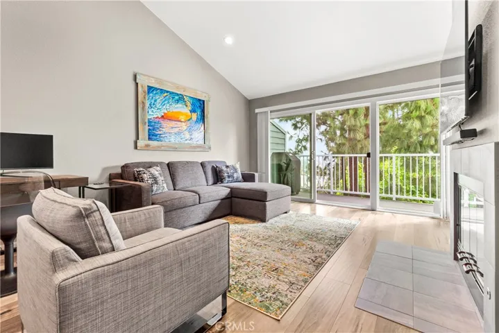 Spacious living room with fireplace, sliders open to balcony