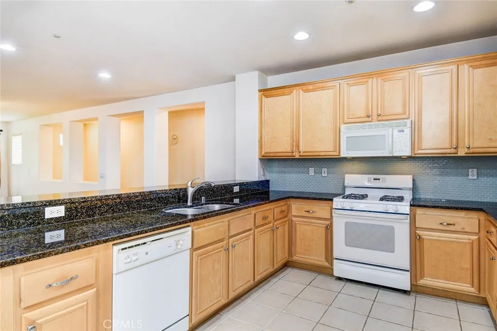 Recessed ceiling lights, granite countertop, glass back splash. Plenty of cabinets space.