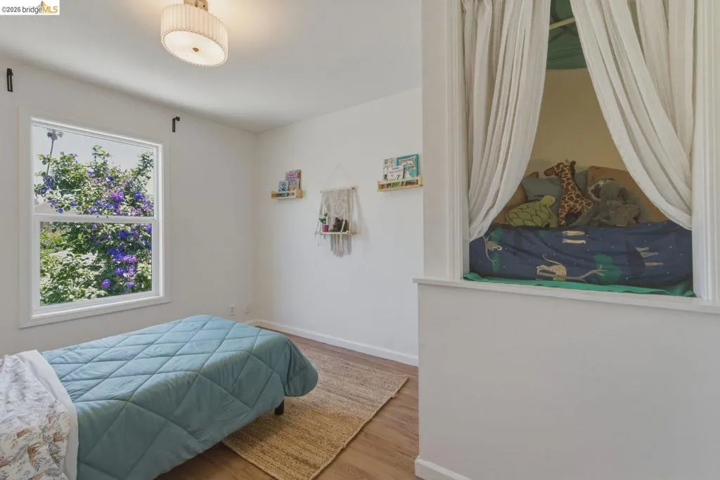 Bright room featuring wood-finish flooring and a contemporary drum ceiling light