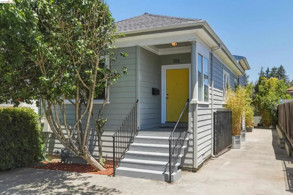 Craftsman-style home featuring light gray siding and a bright yellow entry door