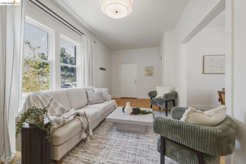 Living area featuring wood-finish flooring, white walls, and a contemporary ceiling light fixture