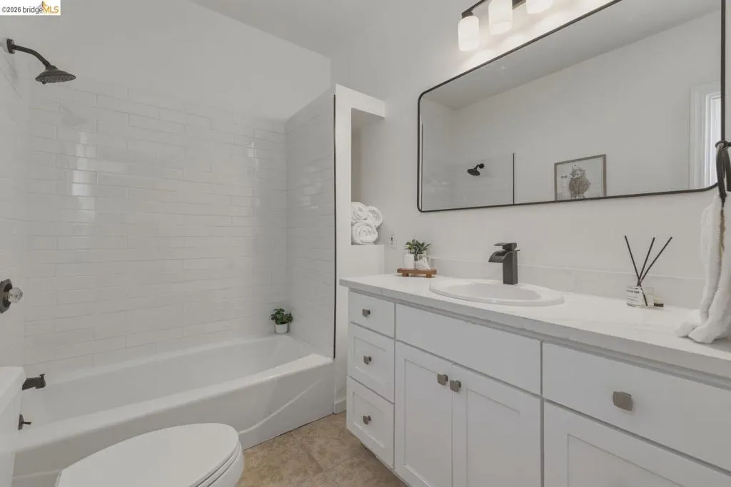 Bathroom featuring a white subway tile shower surround and a white bathtub