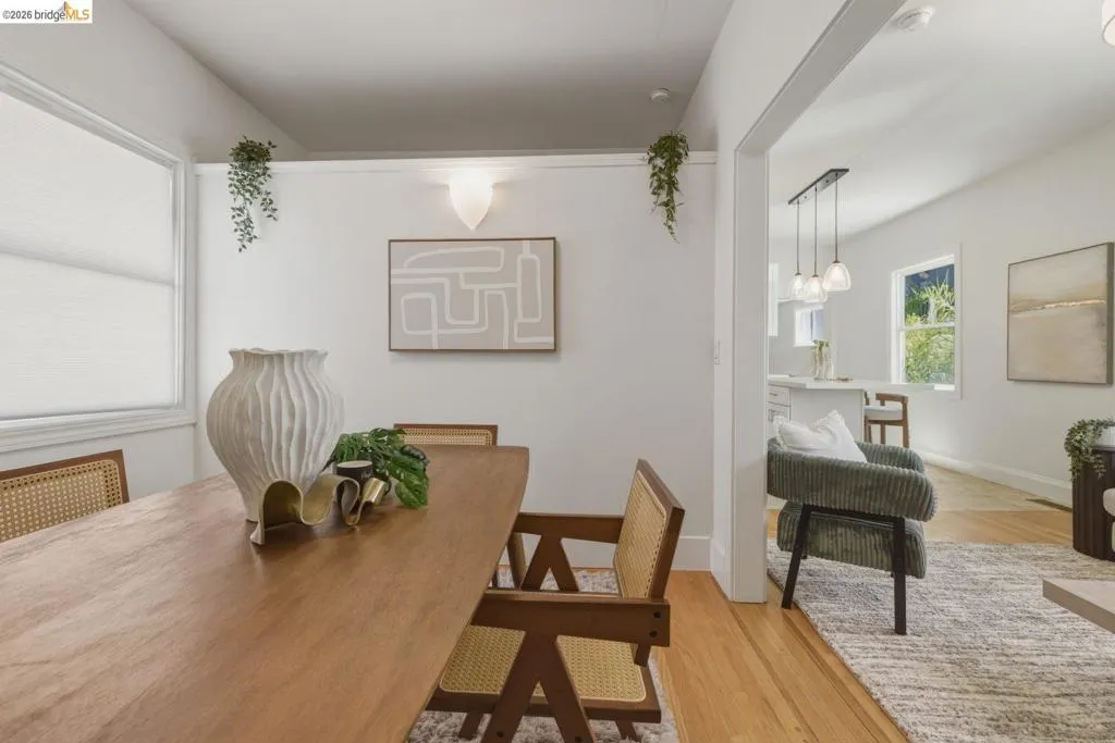 Dining area featuring wood-finish flooring and a contemporary wall sconce