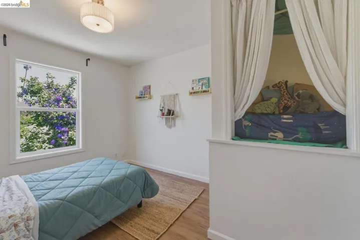 Bright room featuring wood-finish flooring and a contemporary drum ceiling light